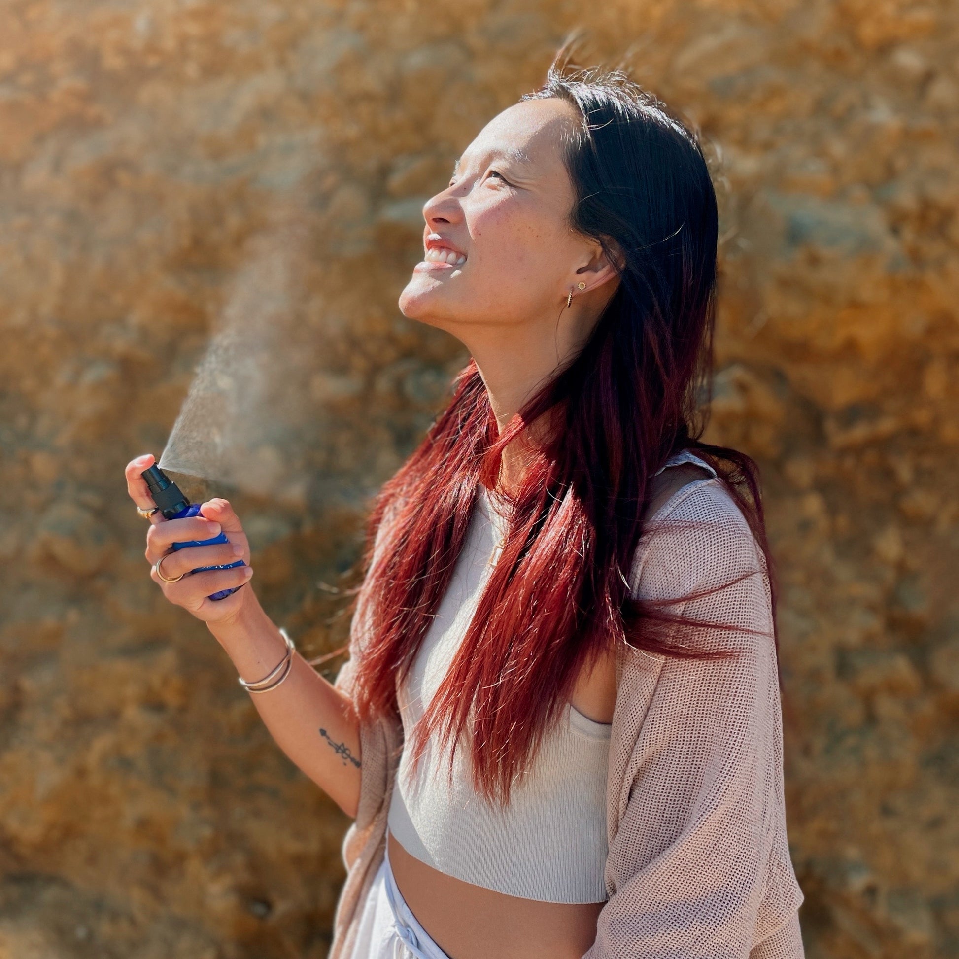 girl spraying clarity mist with blue lotus blue lily essential oil for relaxation