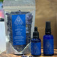 A set of self-care products including a pouch of Blue lotus essential oil and spray bottle, all with labels and displayed on a wooden surface.